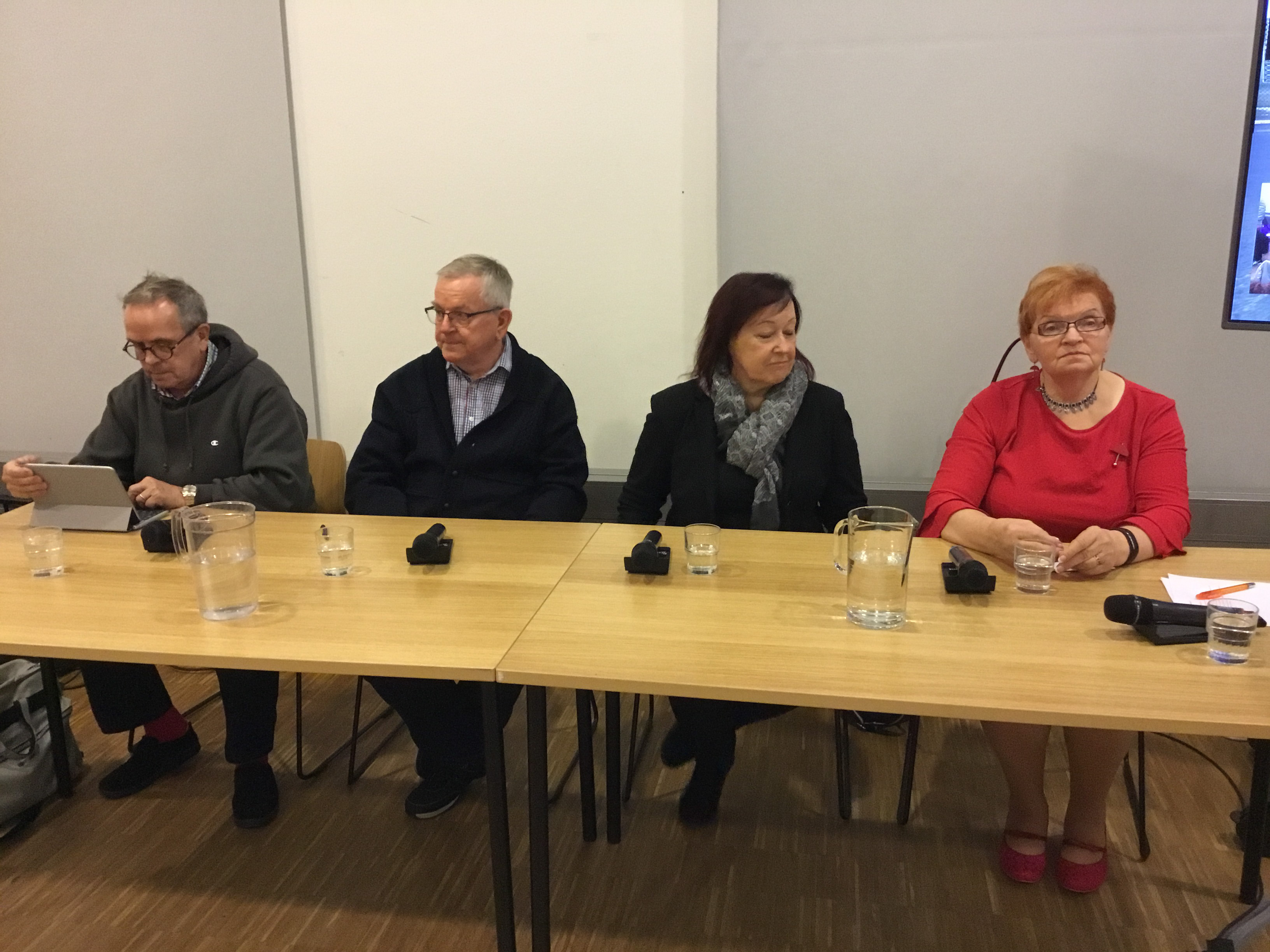 Panelisteja pöydän ääressä